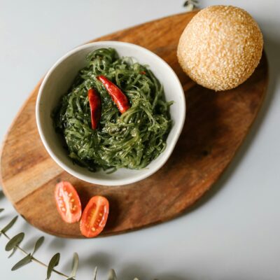 Appetizing seaweed salad with a sesame bun and cherry tomatoes. Perfect for Asian cuisine lovers.